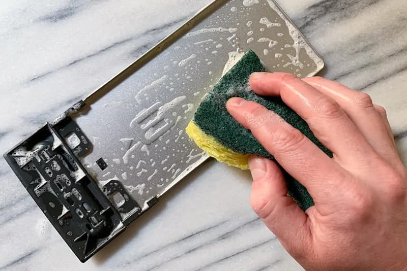 Rửa khay đựng vụn bánh bằng xà bông rửa chén